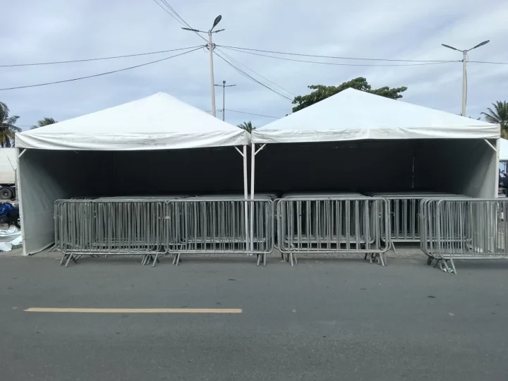 Gradis disciplinadores e tendas em evento de rua