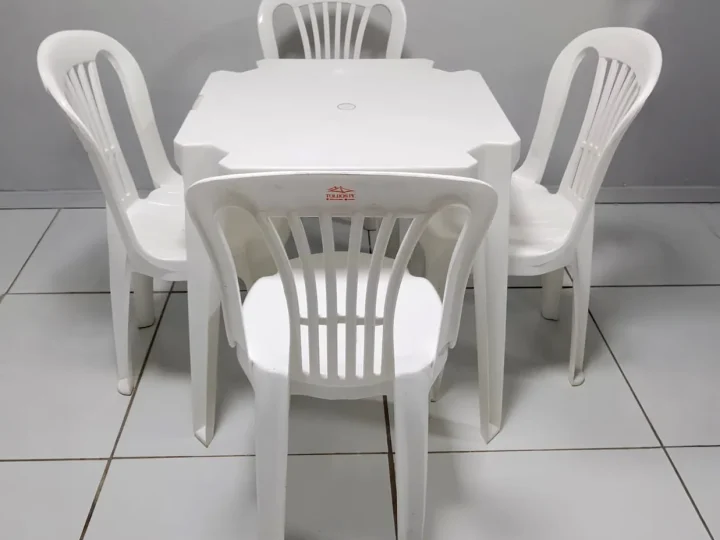 Mesa plástica branca com quatro cadeiras plásticas para locação