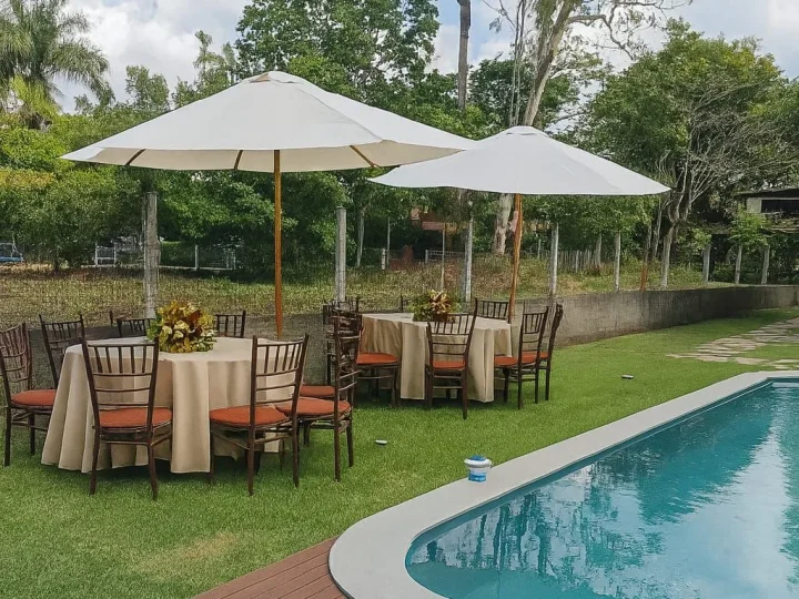 Ombrelones sobre mesas em área de piscina