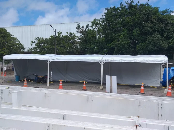 Cobertura montada em frente a um galpão industrial, em área de obra