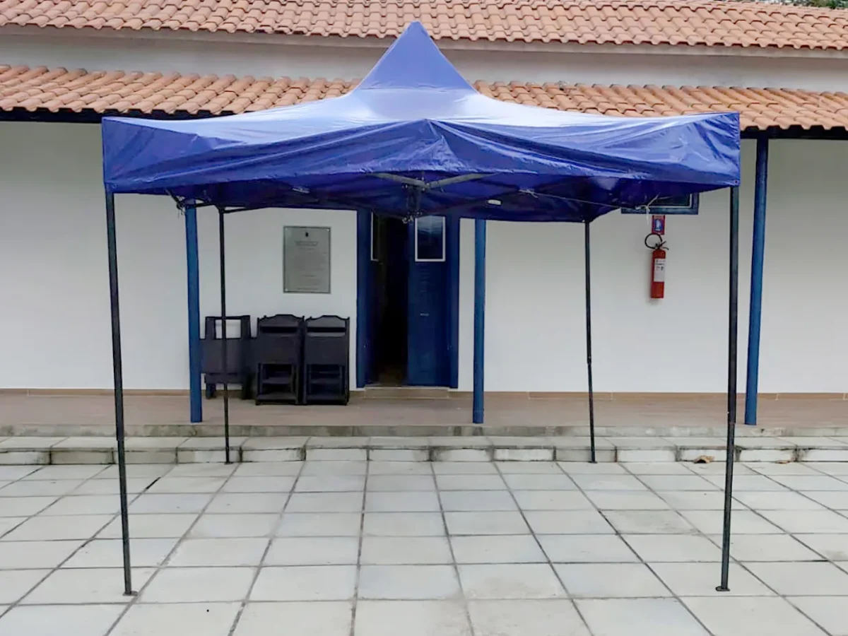 Tenda sanfonada azul 3x3 montada em área externa pavimentada