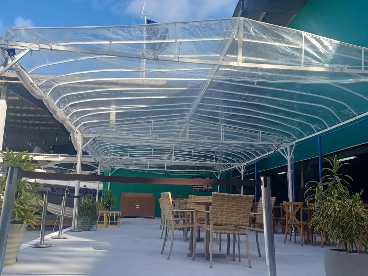 Toldo cristal sobre área de mesas e cadeiras